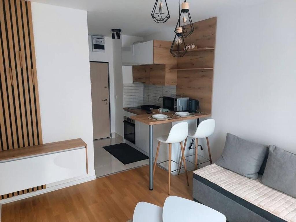 ein Wohnzimmer mit Sofa und eine Küche in der Unterkunft Apartman Lena in Vrnjačka Banja
