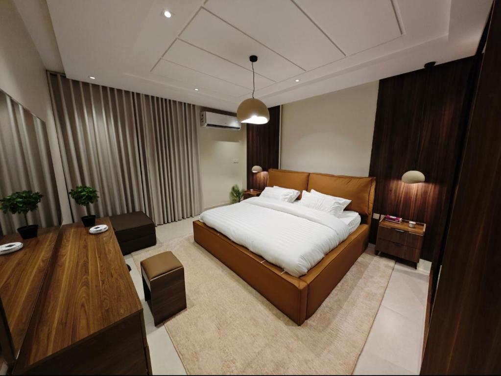 a bedroom with a large bed and a table at luxury stay, great vibes in Al Madinah
