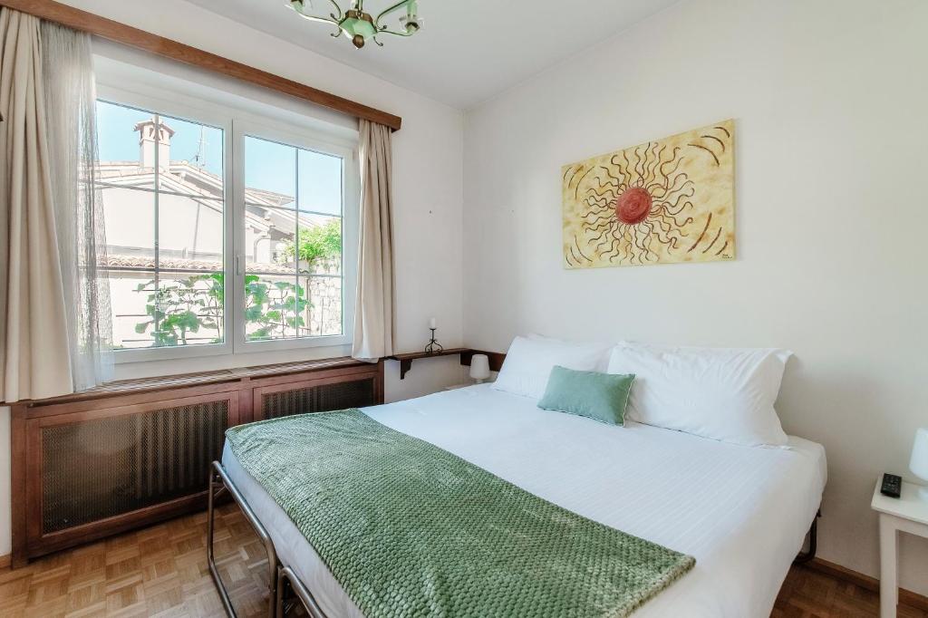 ロゾネにあるAl Capriccio Apartment by Quokka 360 - 5 minutes from the centre of Asconaの白いベッドと窓のある寝室