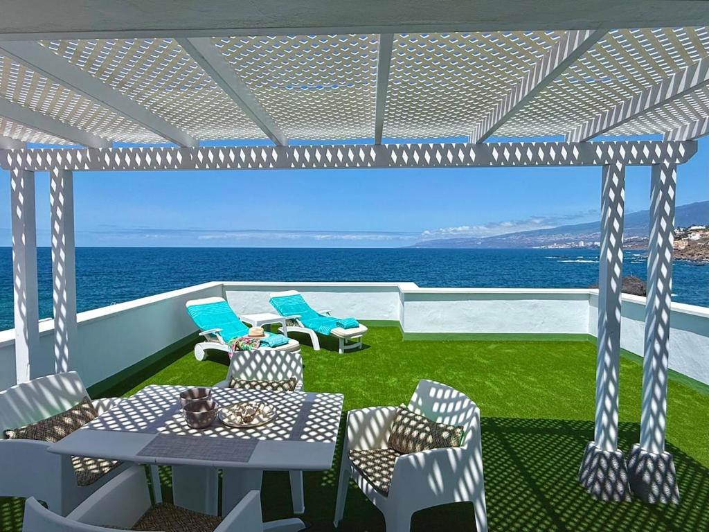 a balcony with a table and chairs and the ocean at Casa Ale, Stunning Sea Views in Las Aguas