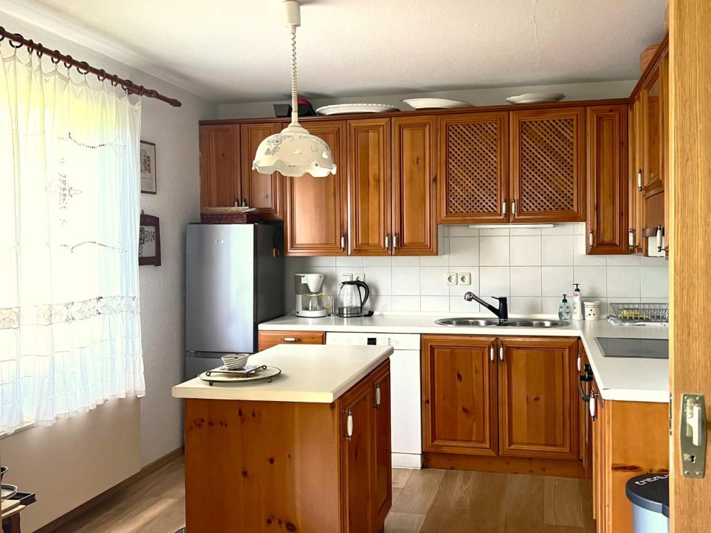 a kitchen with wooden cabinets and a refrigerator at Panoramic Forest Chalet Bled Lake and Castle View in Bled