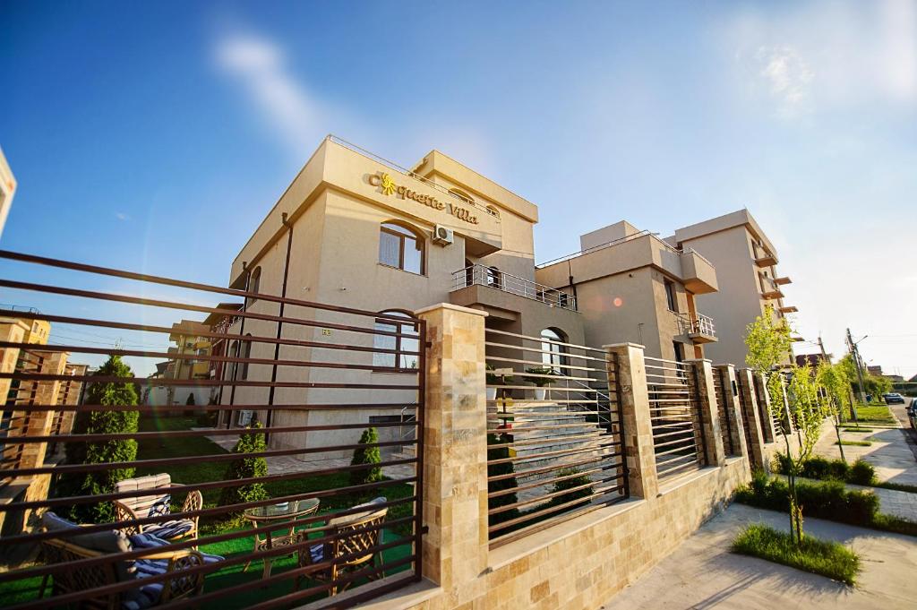 a building with a fence in front of it at Coquette VILLA Mamaia Nord in Mamaia Sat/Năvodari