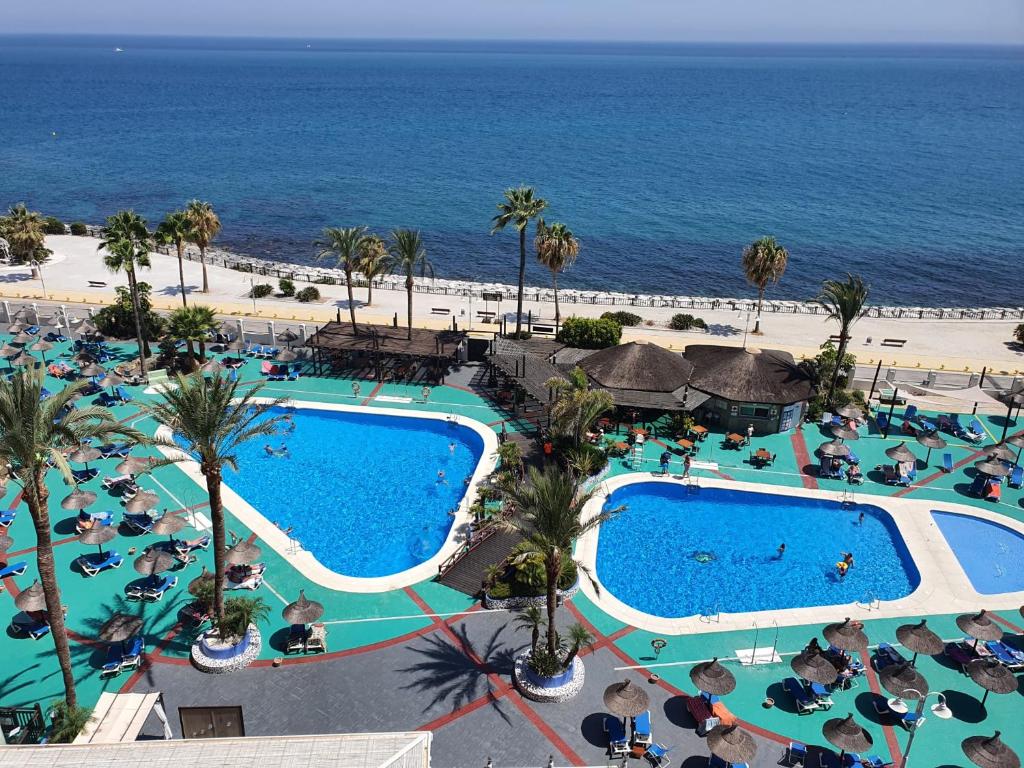 widok z lotu ptaka na ośrodek z basenem i oceanem w obiekcie Atardecer Beach Costa w mieście Benalmádena