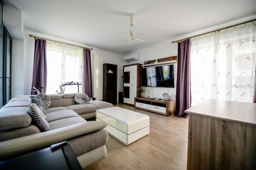 un salon avec un canapé et une télévision dans l'établissement Ruelia, à Bucarest