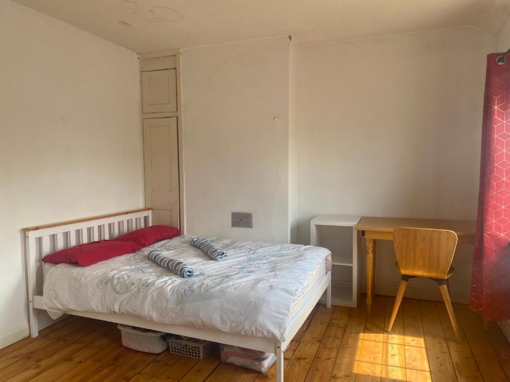 ニューマーケットにあるCharlies House Newmarket - 3 bedroomのベッドと机のある小さな寝室