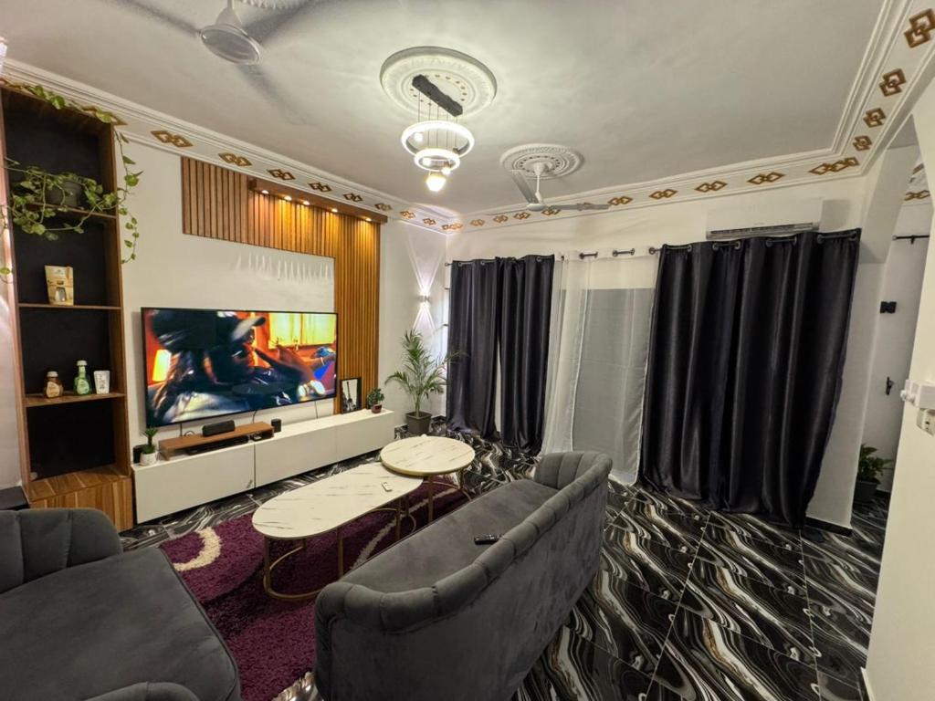 a living room with a couch and a tv at Luxury Nest in Kika