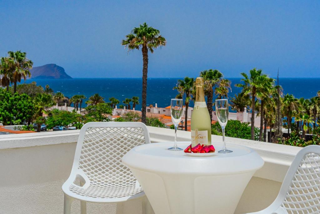 a table with a bottle of champagne and two chairs at Ocean View Duplex Tenerife ( Golf del Sur) in San Miguel de Abona