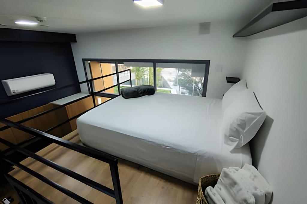 ein Schlafzimmer mit einem großen weißen Bett in einem Zimmer in der Unterkunft Loft Design na Vila Mariana in São Paulo