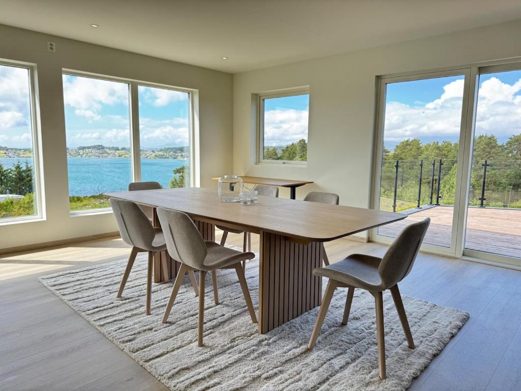 a dining room with a wooden table and chairs at Exclusive penthouse apartment near the sea and nature - Sæbøvik in Sæbøvik