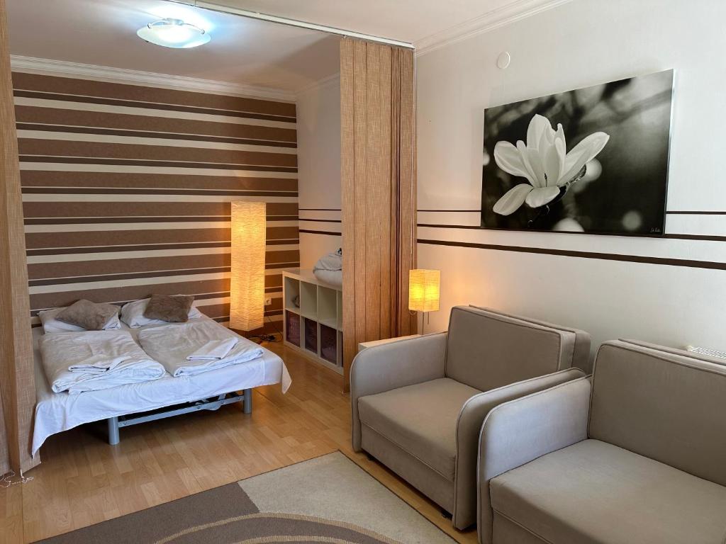 Un dormitorio con una cama, un sofá y una silla. en Art Erika Apartment, en Hajdúszoboszló