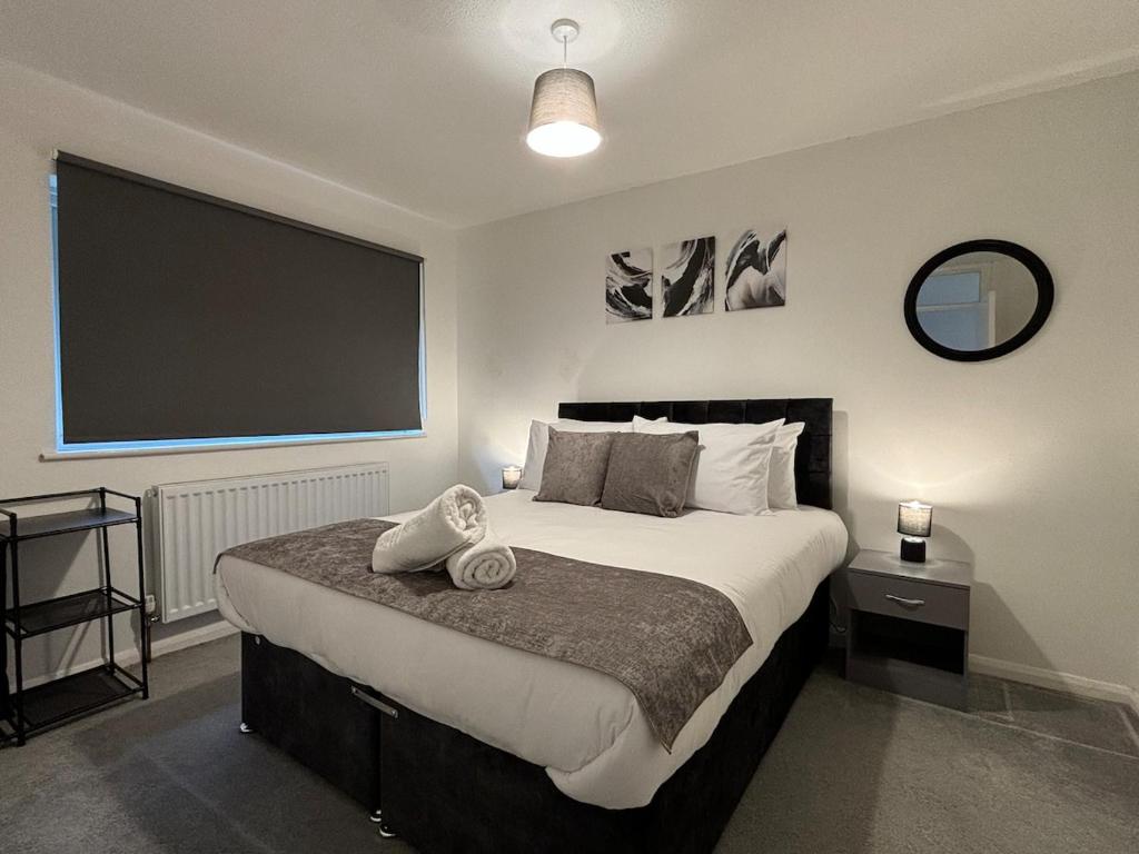 a bedroom with a large bed with a large screen at 4 Bed House - Free Parking - 8 min LGW Airport in Crawley