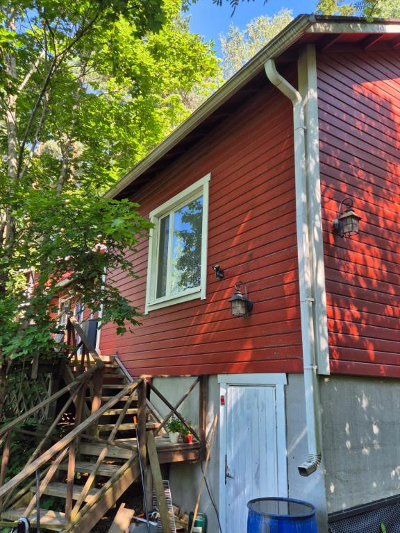 a red house with a stairs leading to a door at Kutala Cottage in Kutala