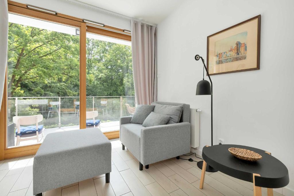 a living room with a couch and a table at Cosy Apartment Parking & Balcony Close to the Kępa Redłowska by Noclegi Renters in Gdynia