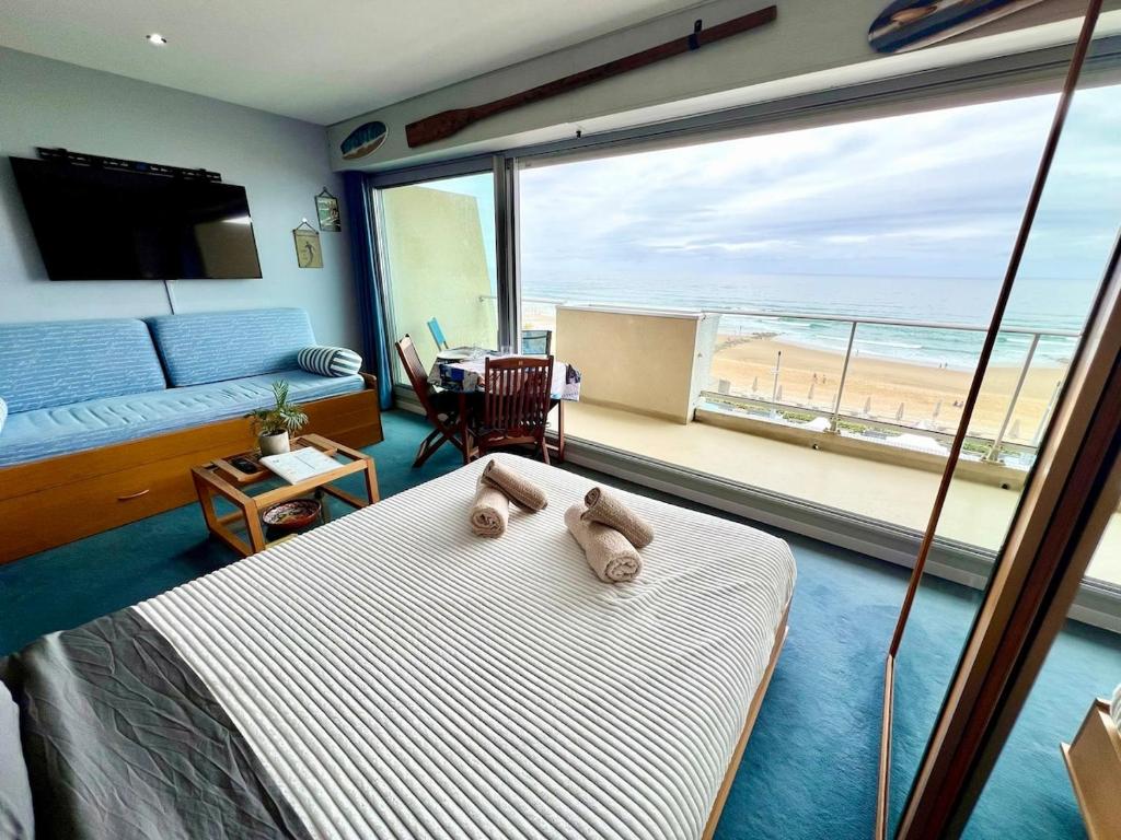 a bedroom with a bed and a view of the beach at Ocean View 2 in Lacanau