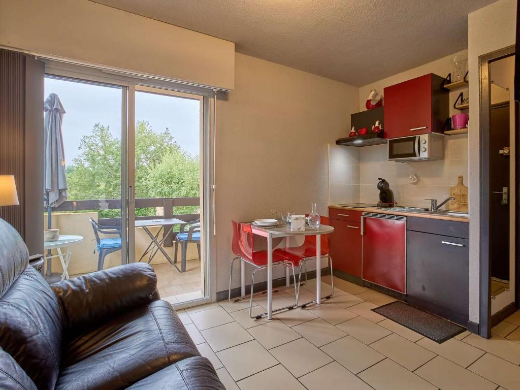 a kitchen with a couch and a table in a kitchen at Charmant appartement lumineux, terrasse, parking gratuit, animaux admis - FR-1-841-36 in Barbotan-les-Thermes