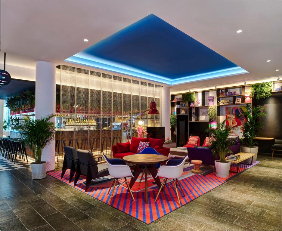 a lobby with a table and chairs and a bar at citizenM Dublin St Patrick's in Dublin