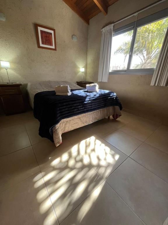 a bedroom with a bed and a window at Complejo de Cabañas Aires de Santiago in San Antonio de Arredondo