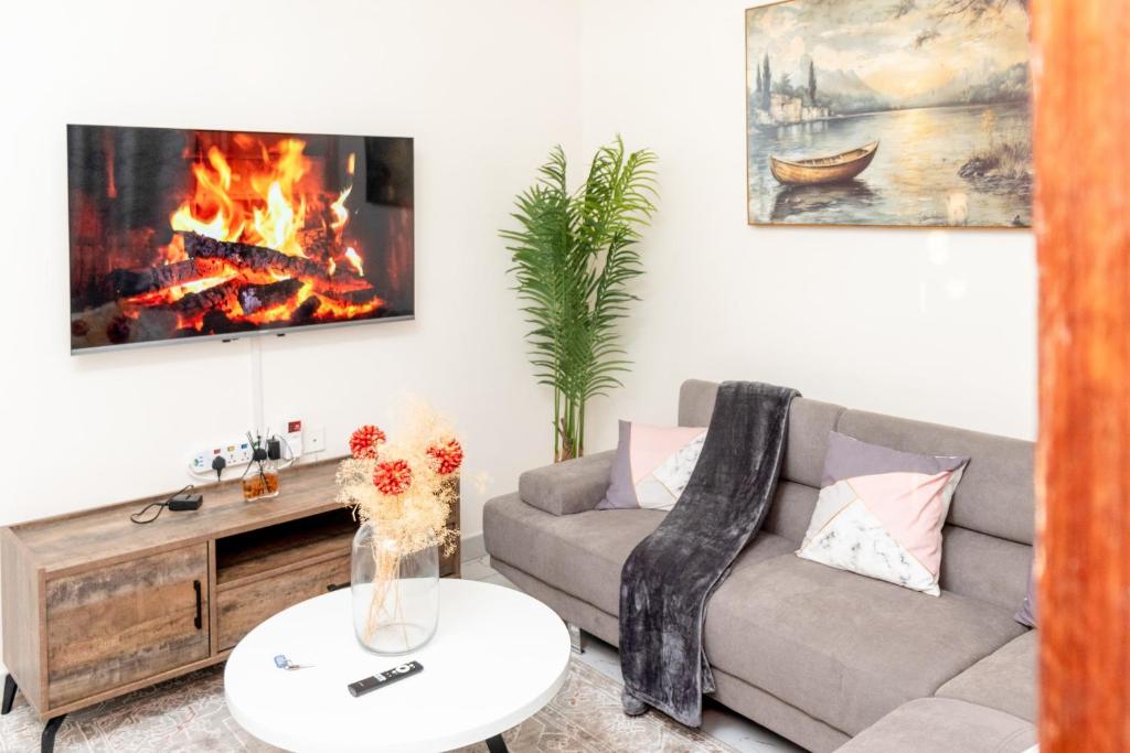 a living room with a couch and a fireplace at Cosy 1 Bedroom in CBD Mombasa with City View in Mombasa