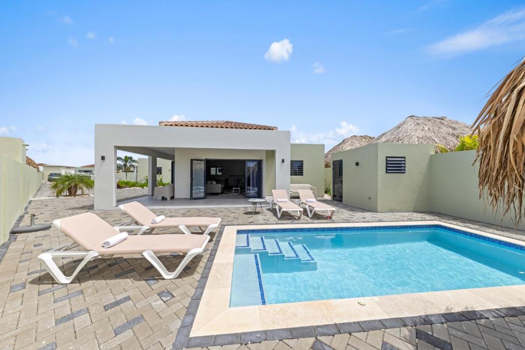 a villa with a swimming pool and a patio at Paradise Villa met privezwembad, Mambo Beach in Willemstad