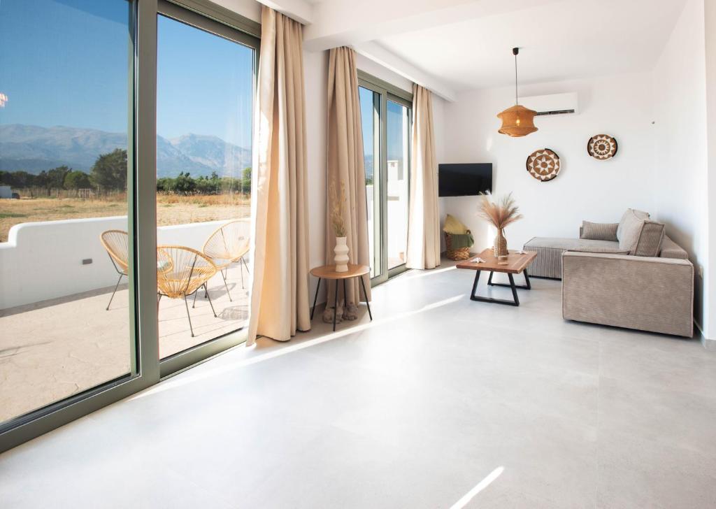 a living room with a couch and a large window at Mediterranean Blue Suites & Villa - Blue Bay Suite in Tympáki