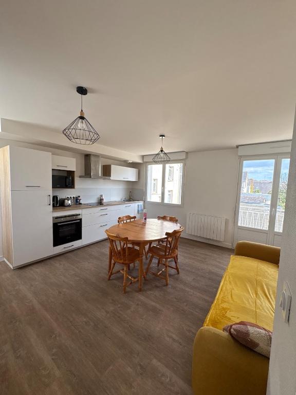un soggiorno con tavolo e cucina di Appartement Cosy et parking a Vannes