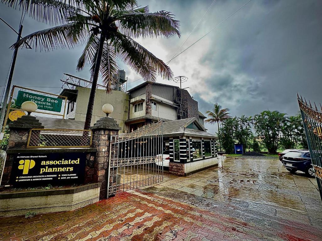 a house with a fence and a palm tree at HoneyBee Resort Lonavala in Lonavala