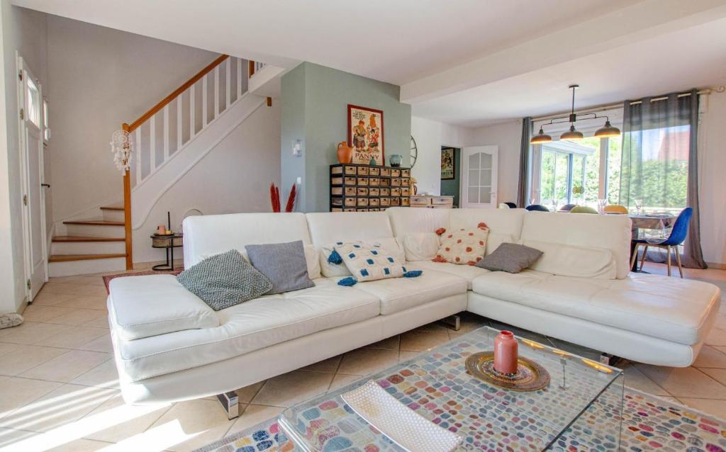 a living room with a white couch and a staircase at Les lys in Saint-Julien-les-Villas