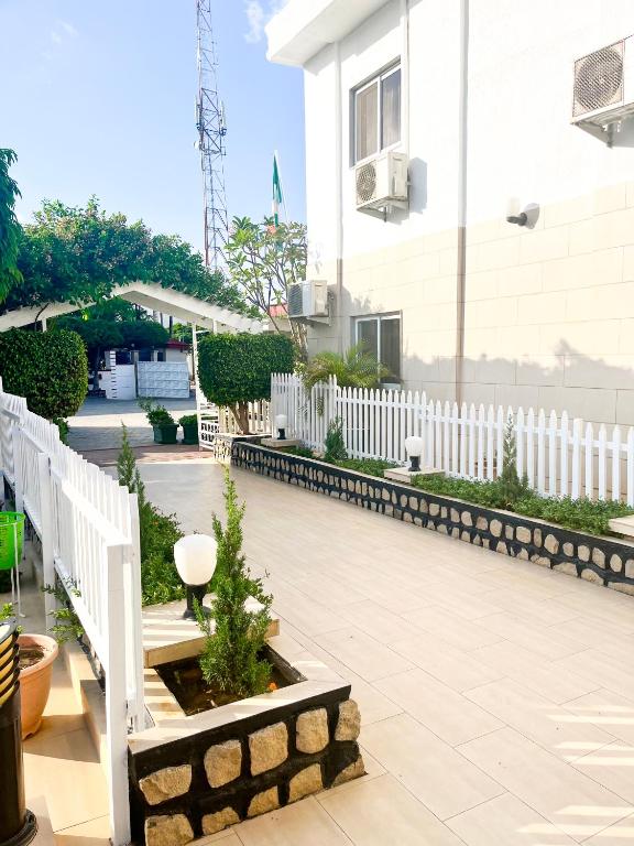 einen weißen Zaun vor einem Gebäude in der Unterkunft Signature Hotel Prince in Kano