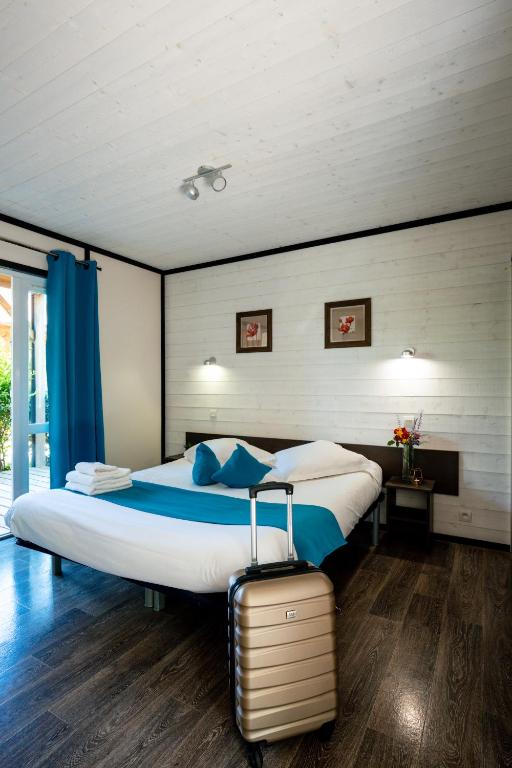 1 dormitorio con 1 cama grande y 1 maleta en Domaine Saint Estève, en Millau