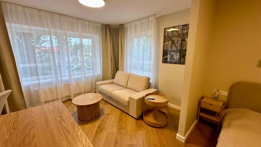 a small living room with a couch and a window at Apartamenti Pētera 28 in Ventspils