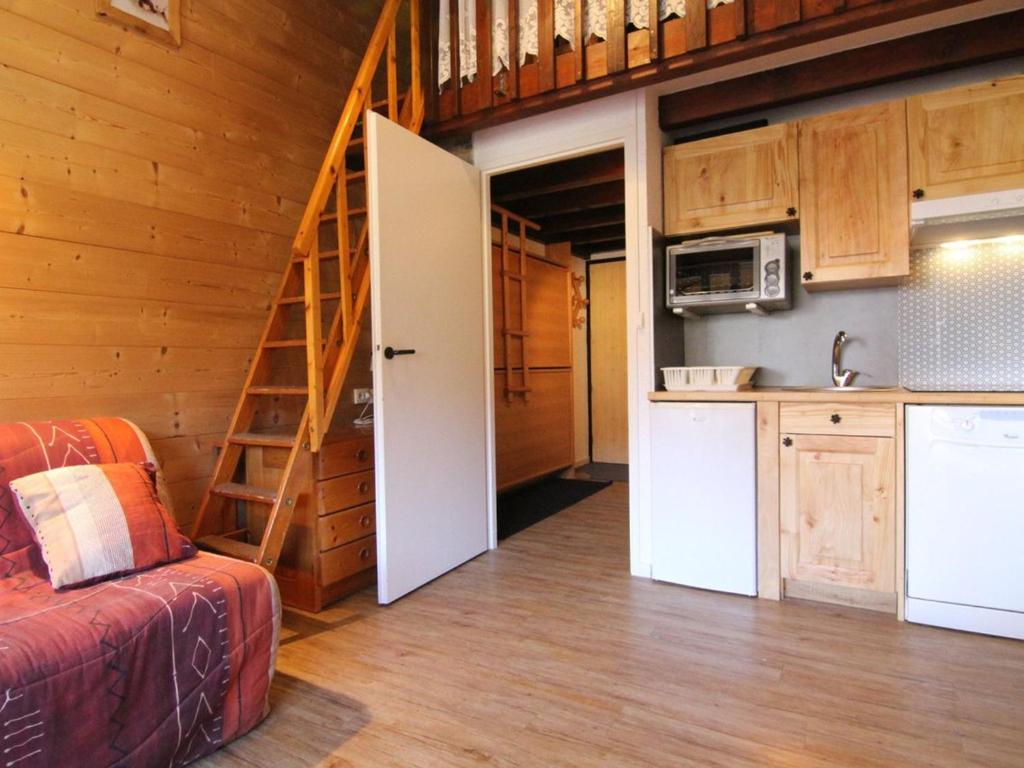 - un salon avec une cuisine et un escalier dans une maison dans l'établissement Charmant 2 pièces avec mezzanine, balcon, et accès direct aux pistes - Vieil Alpe - FR-1-405-80, à L'Alpe-d'Huez