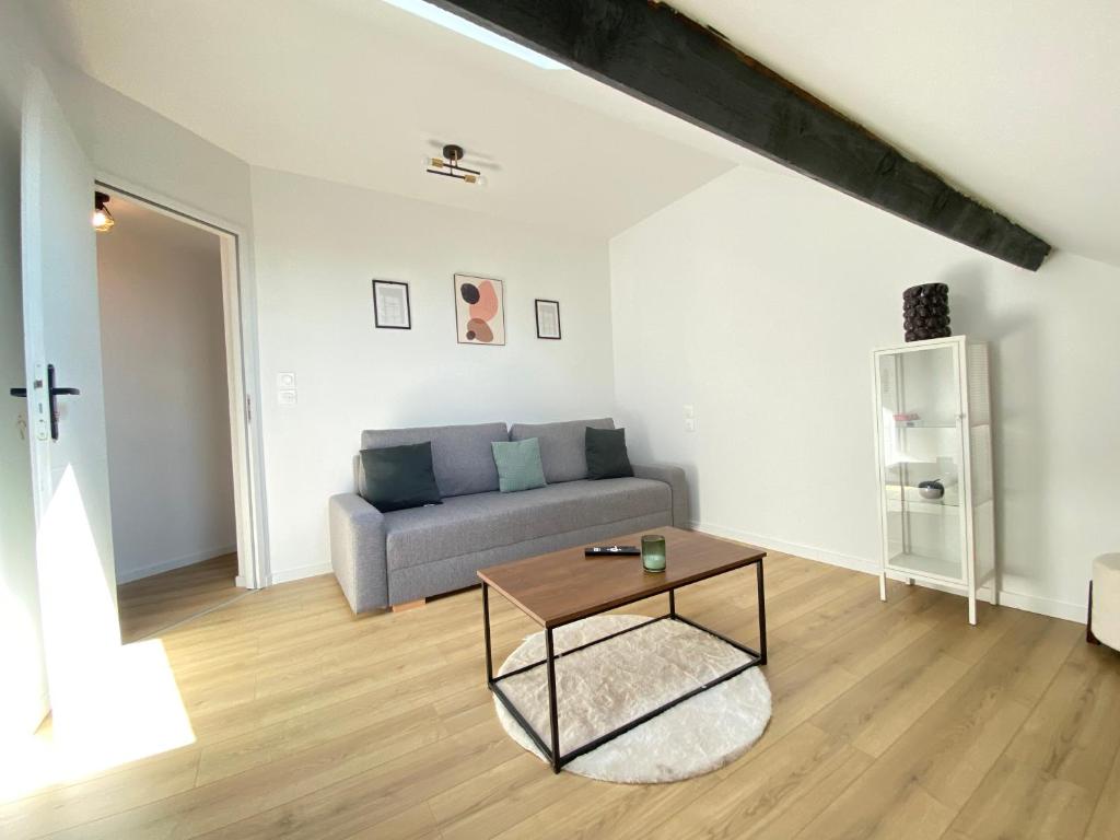 un salon avec un canapé et une table dans l'établissement Appt 4 couchages Jardin Laverie Parking, à Dunkerque