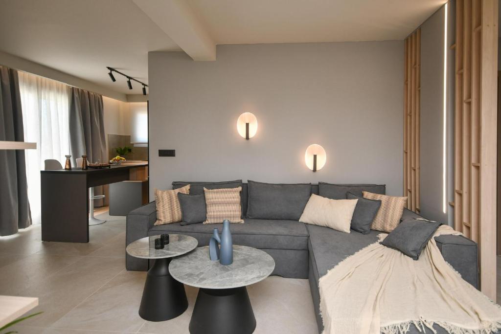 sala de estar con sofá gris y mesas en Holi Top Luxurious Apartment, en Ierápetra