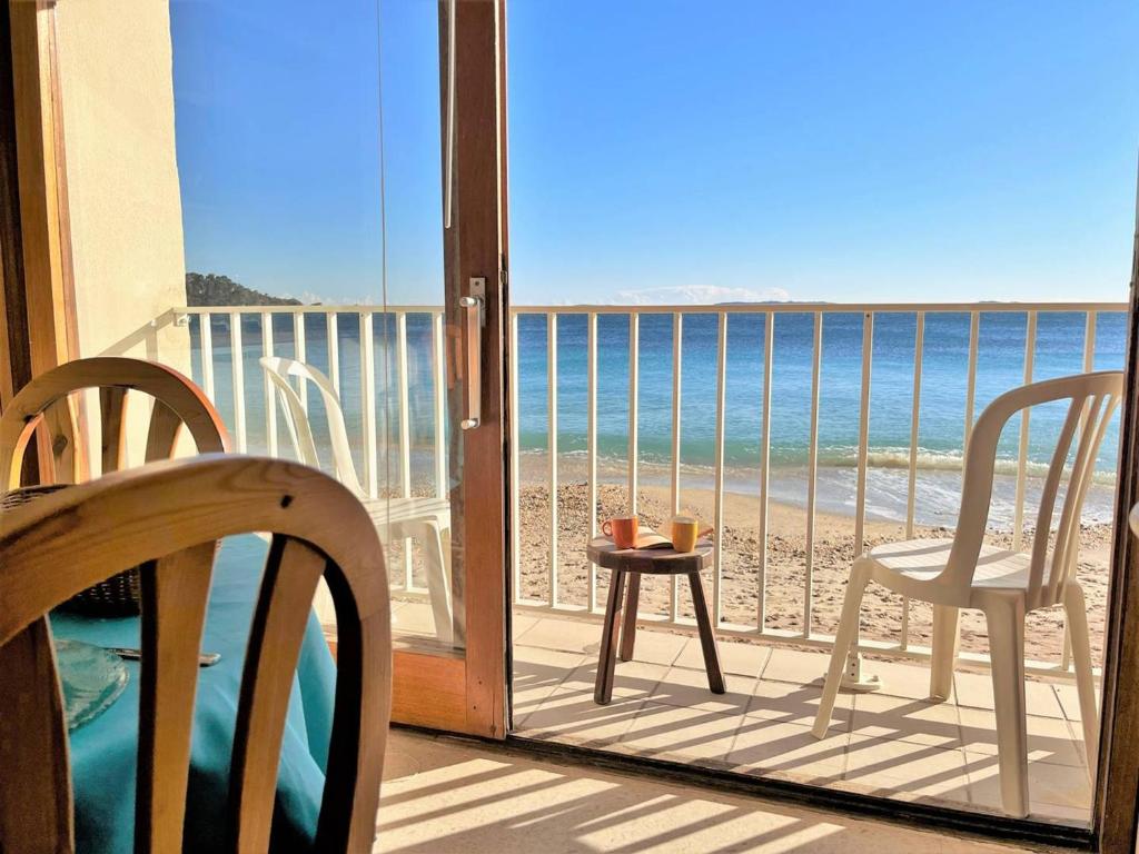 d'un balcon avec des chaises et une table offrant une vue sur la plage. dans l'établissement Studio lumineux 4 couchages près de la plage avec options linge et Wifi - FR-1-251-433, au Lavandou