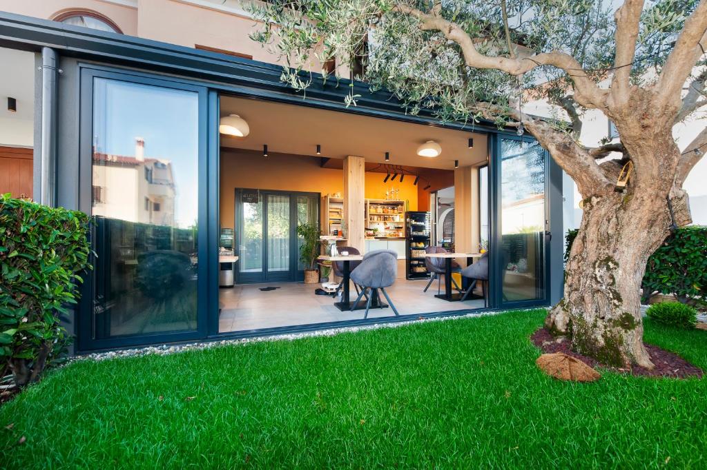 a glass extension of a house with a tree at Villa Milli B&B in Rovinj