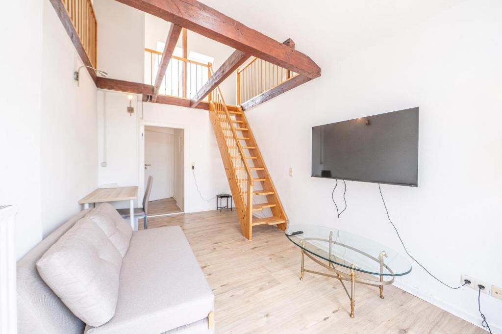 un salon avec un canapé et une télévision à écran plat dans l'établissement Charmante Maisonette im Herzen des Magniviertels - Stilvoll, Zentral & Gemütlich, à Brunswick