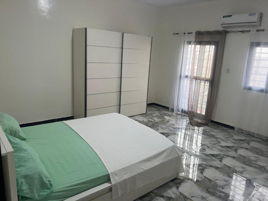 a bedroom with a bed and a dresser at Studio meublé Saint Louis Sénégal in Saint-Louis