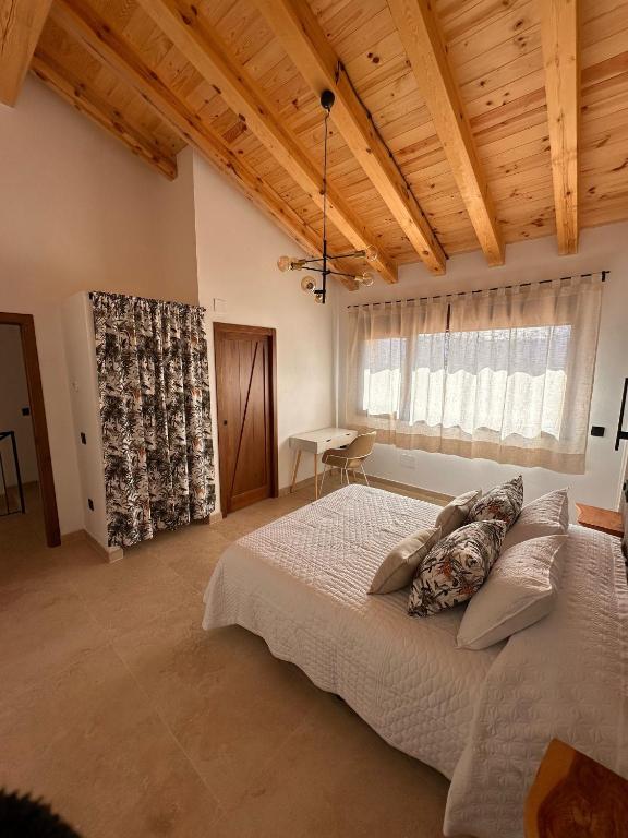 a bedroom with a large bed and a wooden ceiling at Casa rural Los Acebos in La Cuesta
