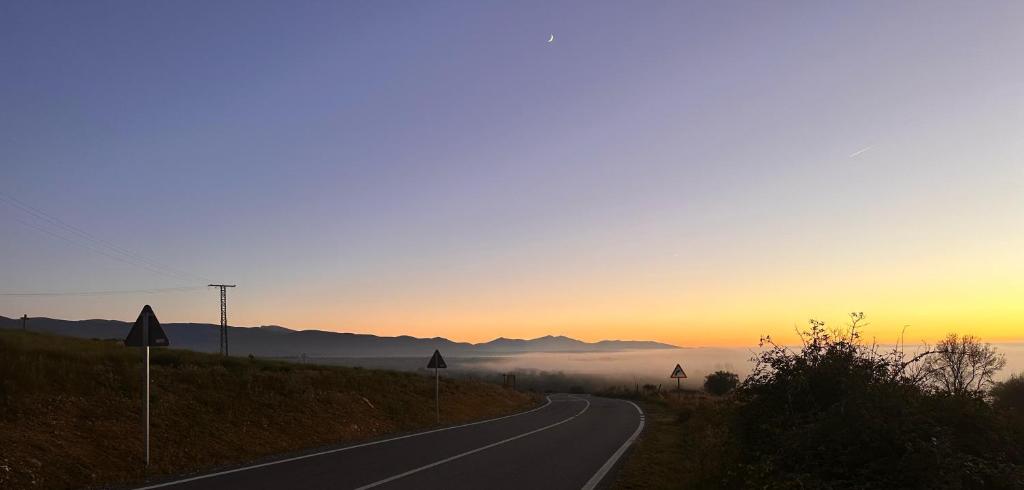 an empty road with the sunset in the background at Casa rural Los Acebos in La Cuesta