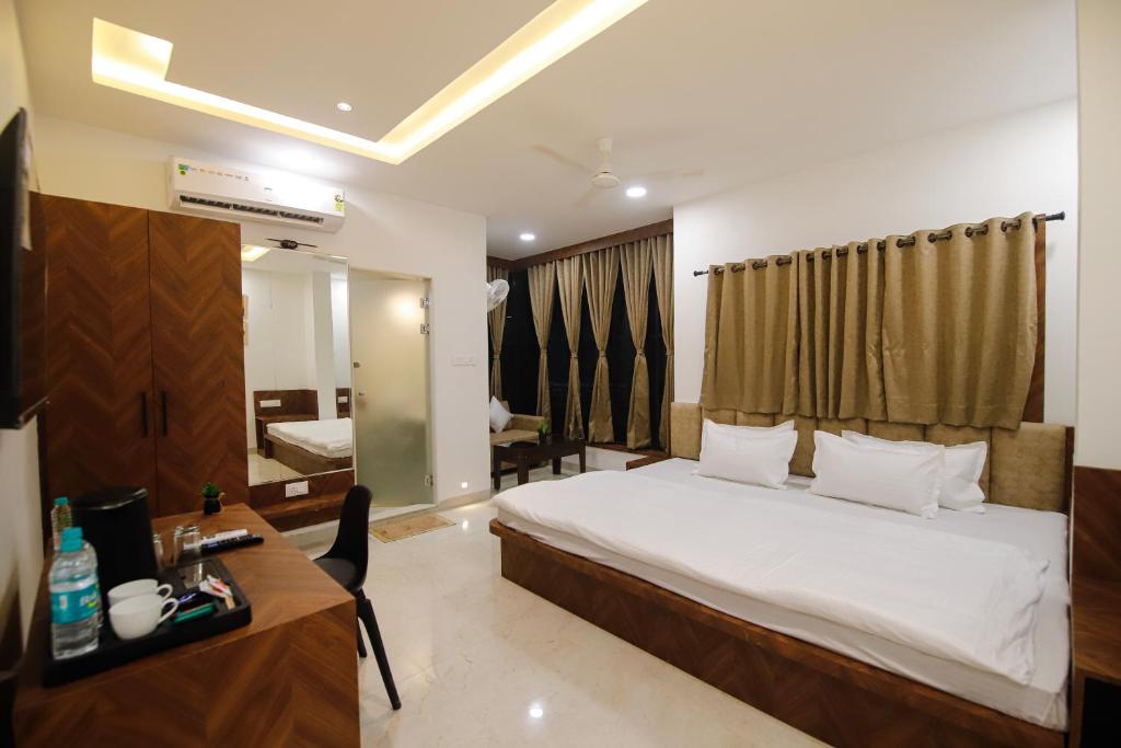 a hotel room with a bed and a desk and a bedroom at Hotel Super Stay in Ujjain