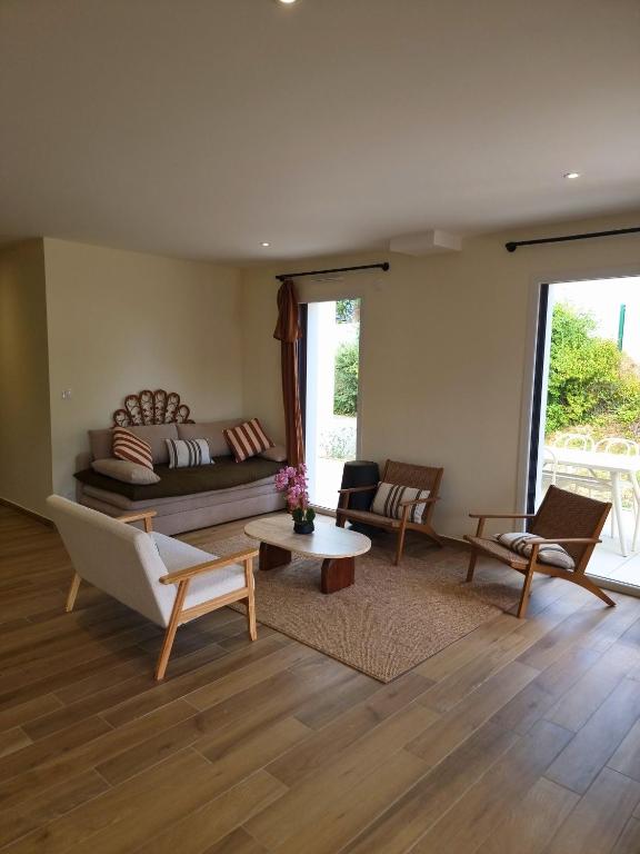 un salon avec un canapé et des chaises dans l'établissement Maison proche de la mer, à Pénestin