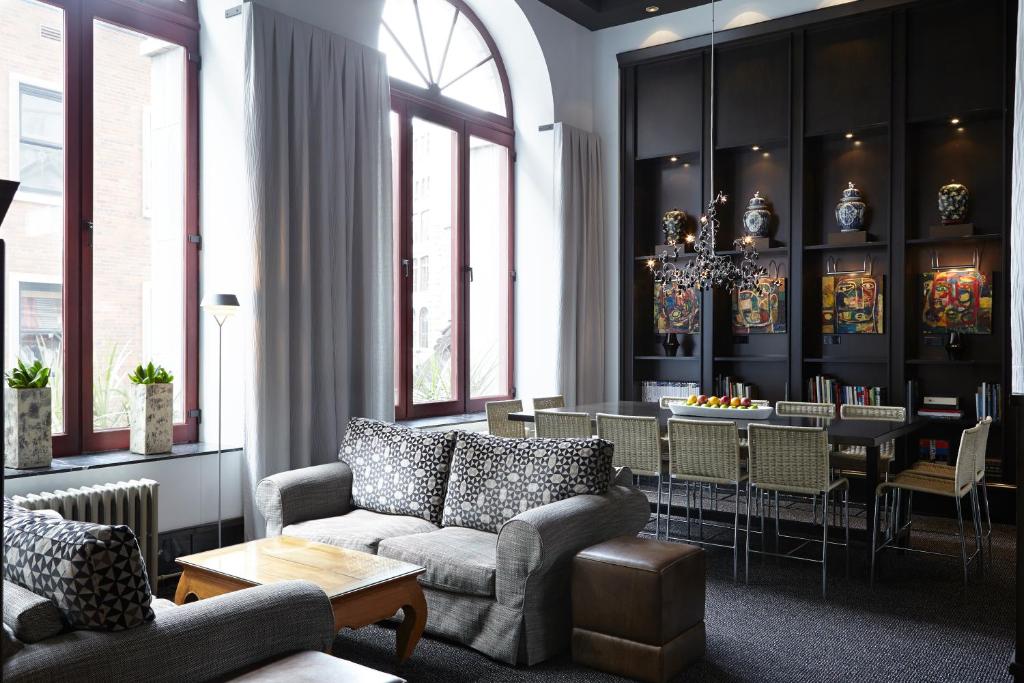 a living room with a couch and a dining room at Hôtel Le Germain Québec in Quebec City