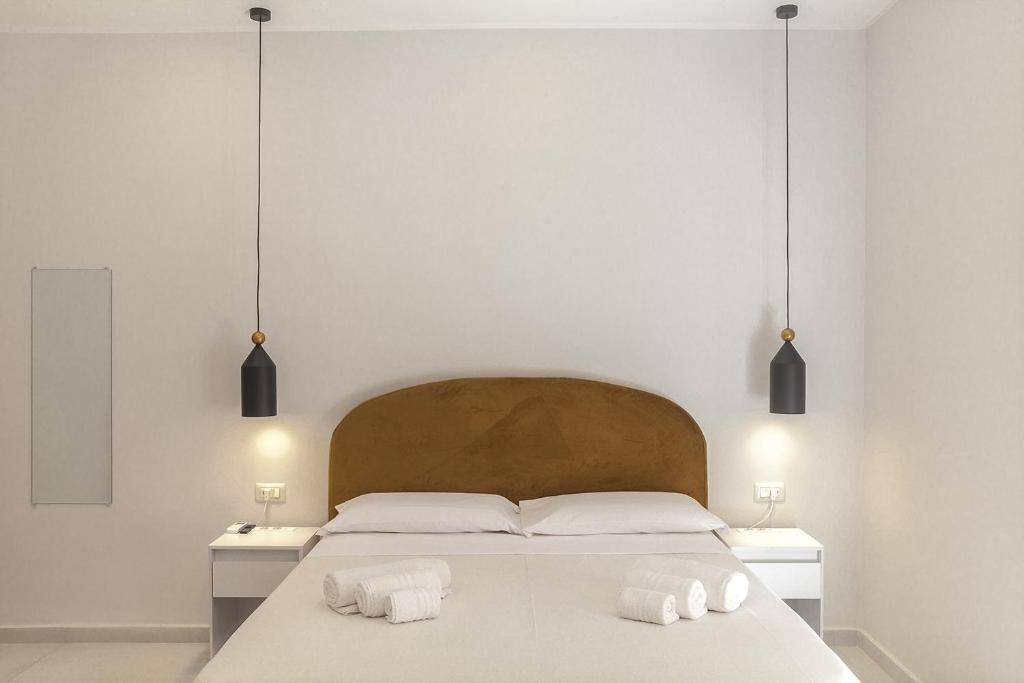 a bedroom with a large white bed with two towels at B&B PierGaia in Santa Maria di Castellabate