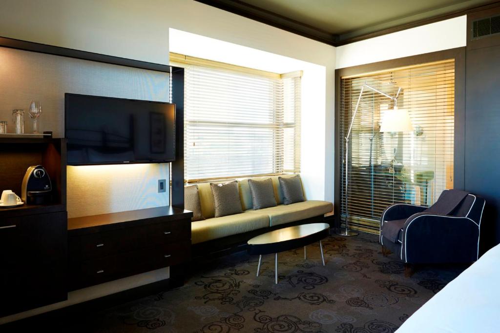 a living room with a couch and a flat screen tv at Hôtel Le Germain Québec in Quebec City