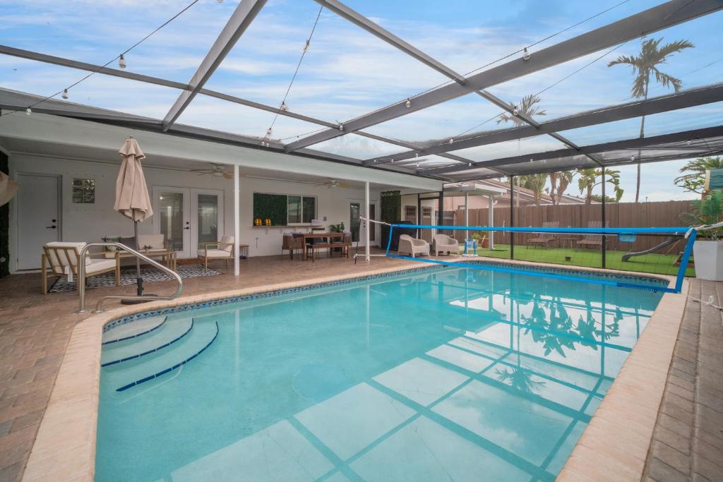 a large swimming pool with a retractable roof at Sunrise Serenade - Sun-Soaked FLL Getaway - Pool - BBQ - Near Beaches in Sunrise