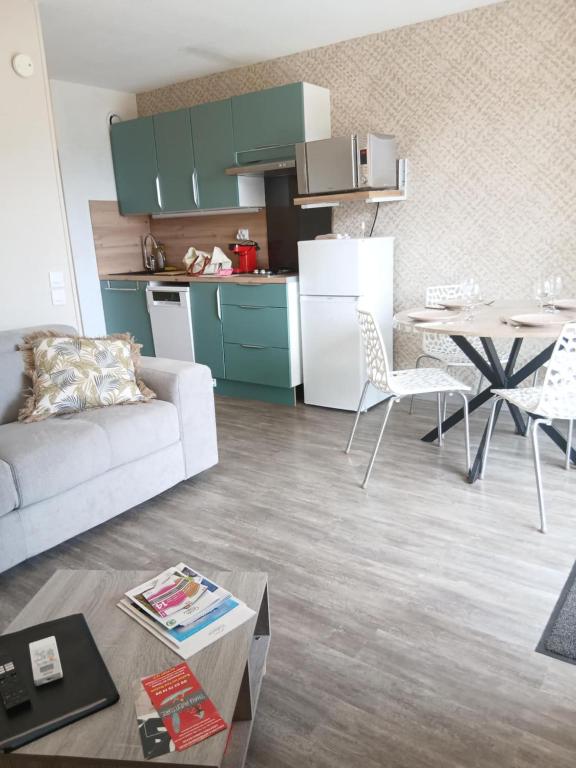 un salon avec un canapé et une table et une cuisine dans l'établissement Harmonie des Thermes, à Balaruc-les-Bains