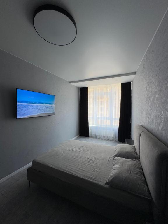 a bedroom with a large bed and a window at Arcadia Apartments in Odesa