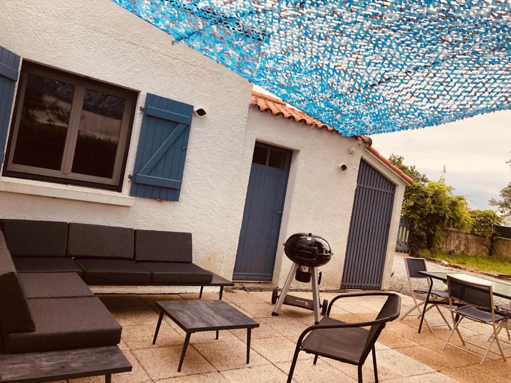 d'une terrasse avec des chaises et un barbecue. dans l'établissement Maison de campagne proche de la côte, à Chauvé