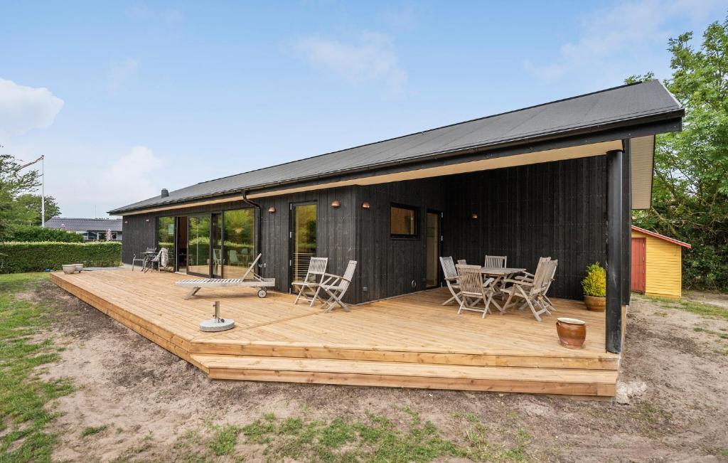 a large wooden deck with chairs and a table at Stunning Home In Juelsminde With Wifi in Sønderby