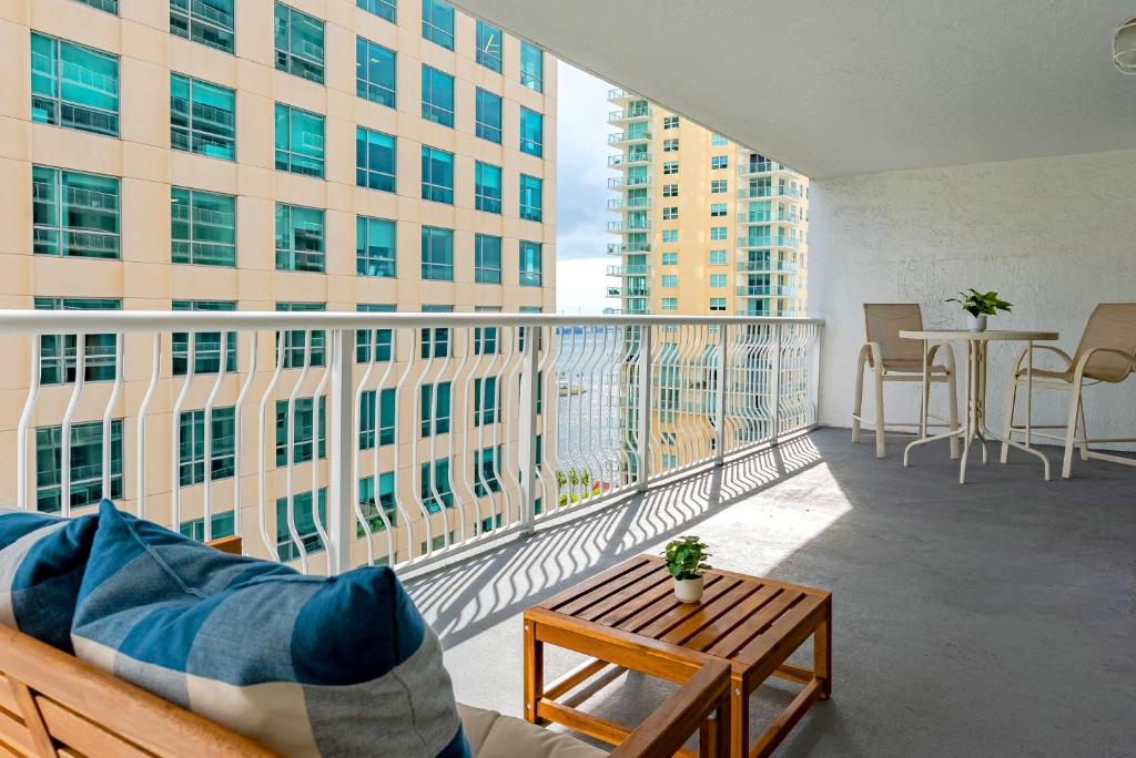 a balcony with a couch and a table on a building at Brickell Condo w City View & Pool Access in Miami